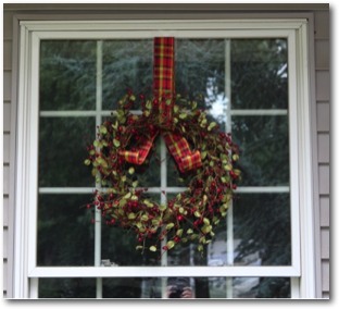 Wreath hung on window with Wreath Pro adjustable wreath hanger.